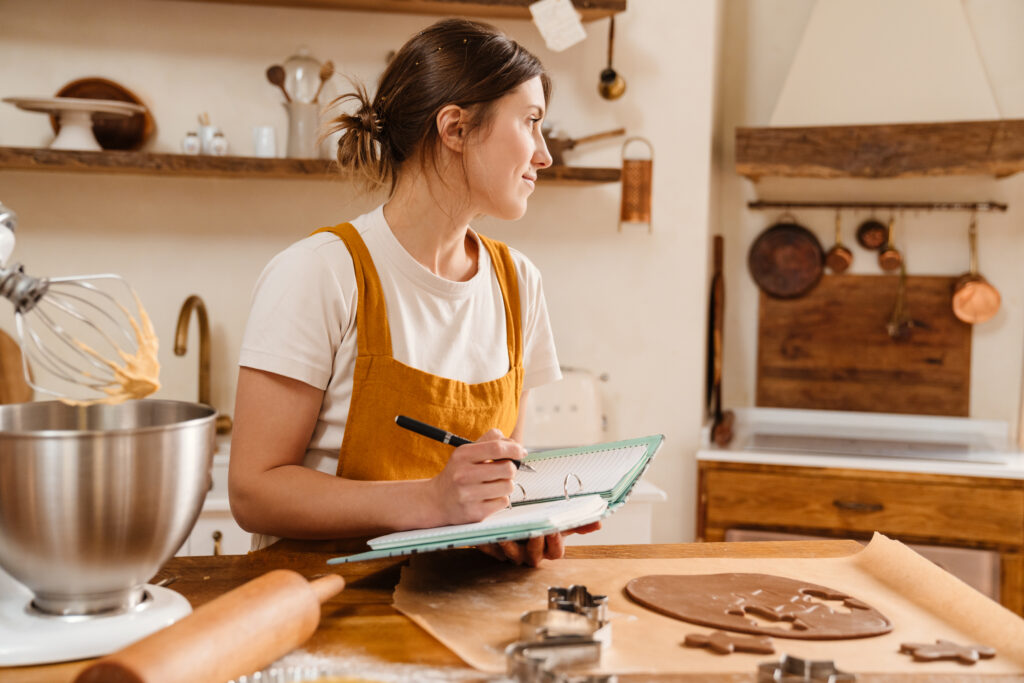 mulher-em-ambiente-de-cozinha-escrevendo-em-um-planner 