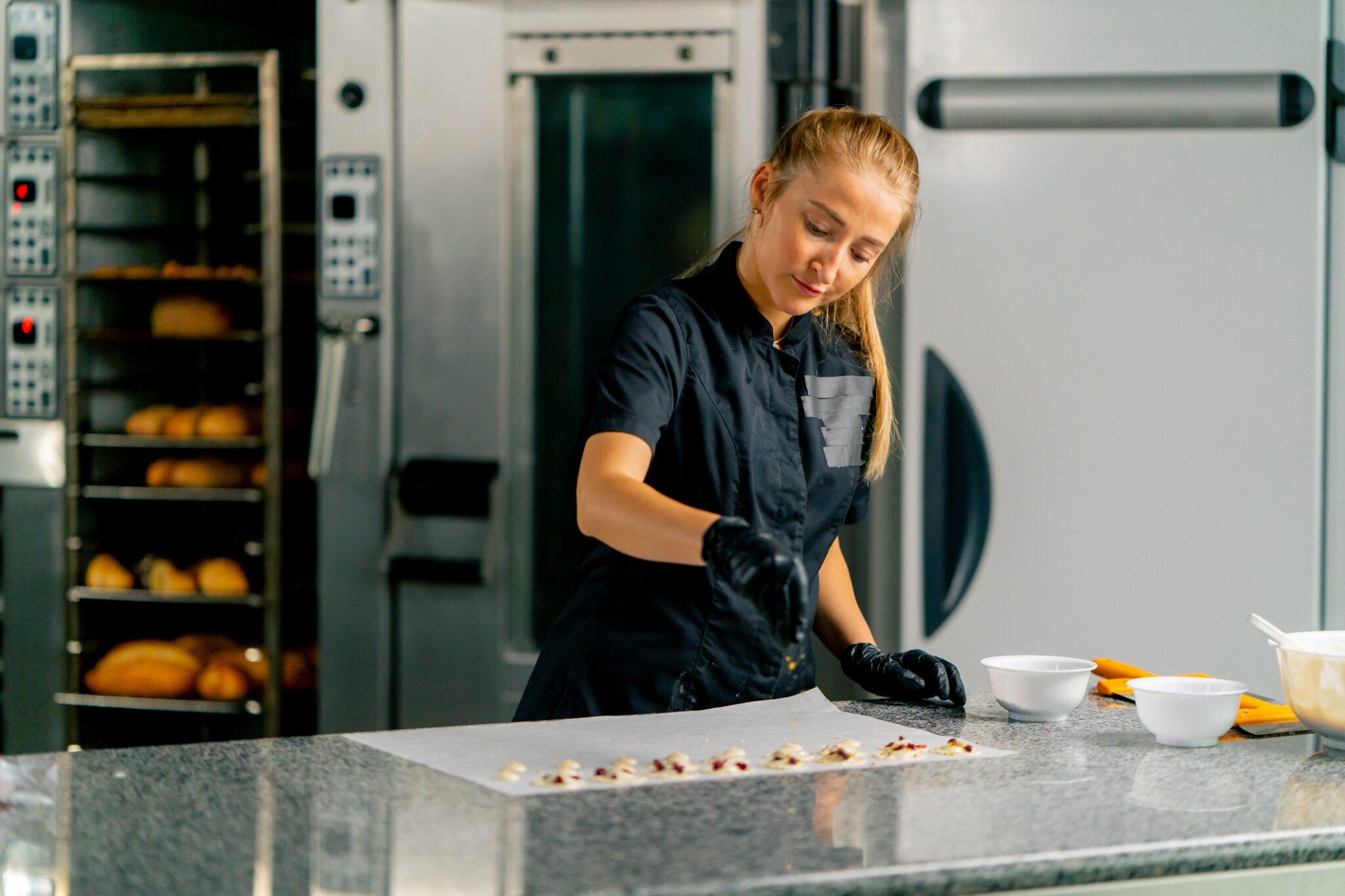 profissional-em-cozinha-industrial-finalizando-receitas-de-confeitaria-na-bancada